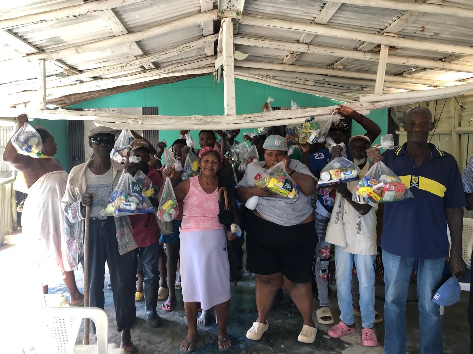 Un grupo de personas muestra bolsas con alimentos